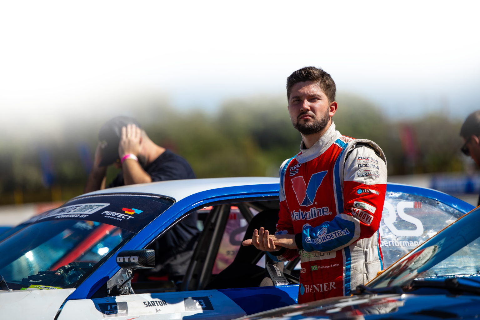 Matheus Sartor orientando um piloto ao lado do carro